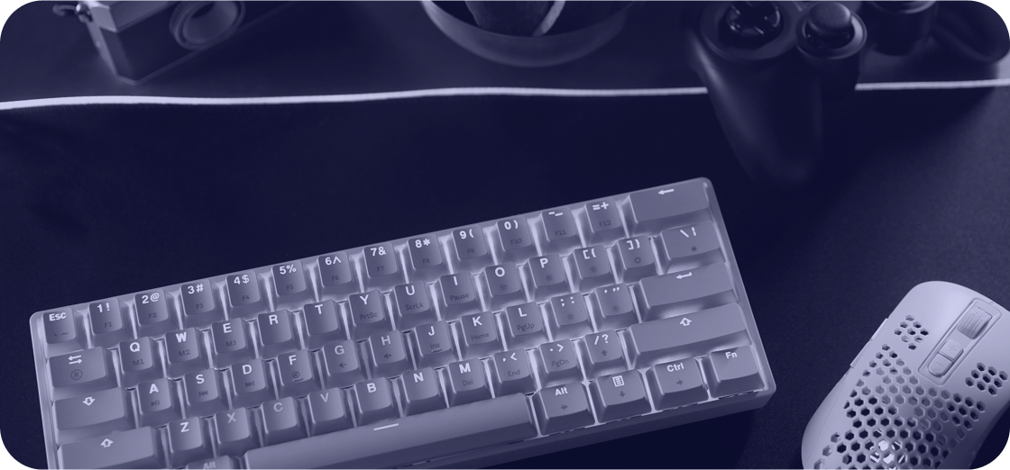 Vista superior de un escritorio con un teclado moderno, mouse y un joystick